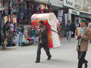 Man carrying items up and down the road in Shimla